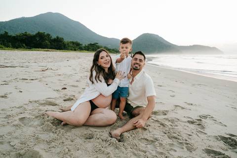 Família reunida durante ensaio gestante ao ar livre em Ubatuba.'