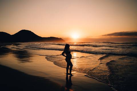 Ensaio gestante na praia em Ubatuba realizado ao nascer do sol.'