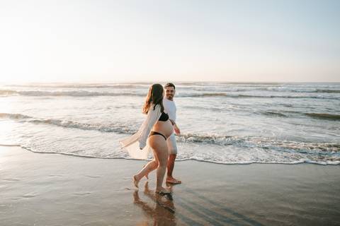 Casal durante ensaio gestante na praia de Ubatuba aguardando a chegada do bebê.'