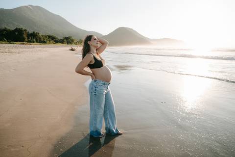 Ensaio gestante na praia em Ubatuba realizado ao pôr do sol.'