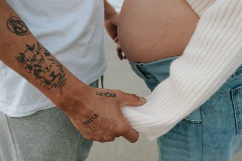 Fotografia de gestante em Ubatuba destacando a barriga durante ensaio na praia.'