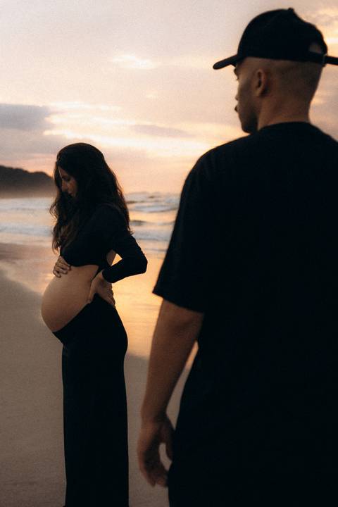 Casal durante ensaio gestante na praia de Ubatuba aguardando a chegada do bebê.'