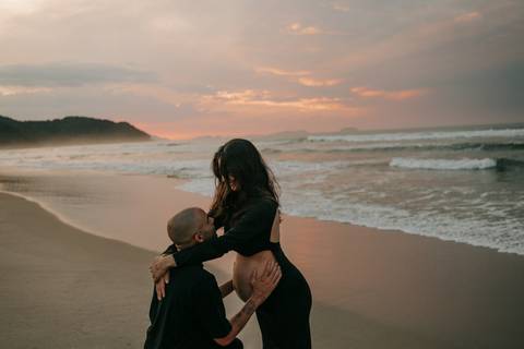 Casal durante ensaio gestante na praia de Ubatuba aguardando a chegada do bebê.'