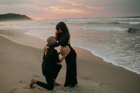 Casal durante ensaio gestante na praia de Ubatuba aguardando a chegada do bebê.'