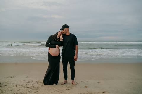 Casal durante ensaio gestante na praia de Ubatuba aguardando a chegada do bebê.'