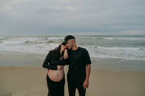 Casal durante ensaio gestante na praia de Ubatuba aguardando a chegada do bebê.'