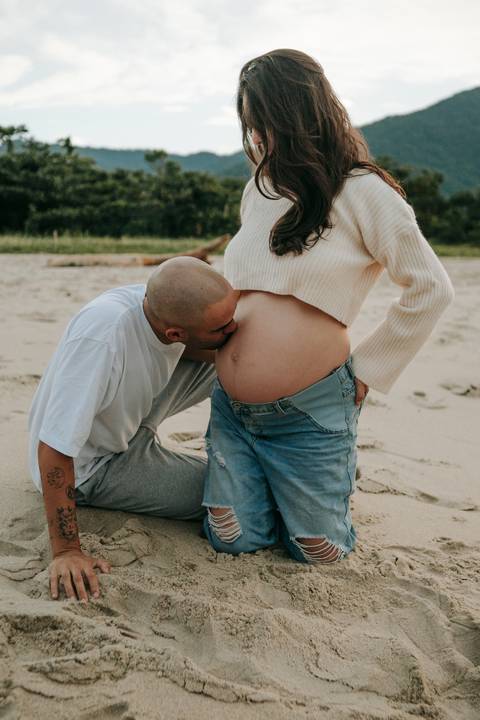 Casal durante ensaio gestante na praia de Ubatuba aguardando a chegada do bebê.'