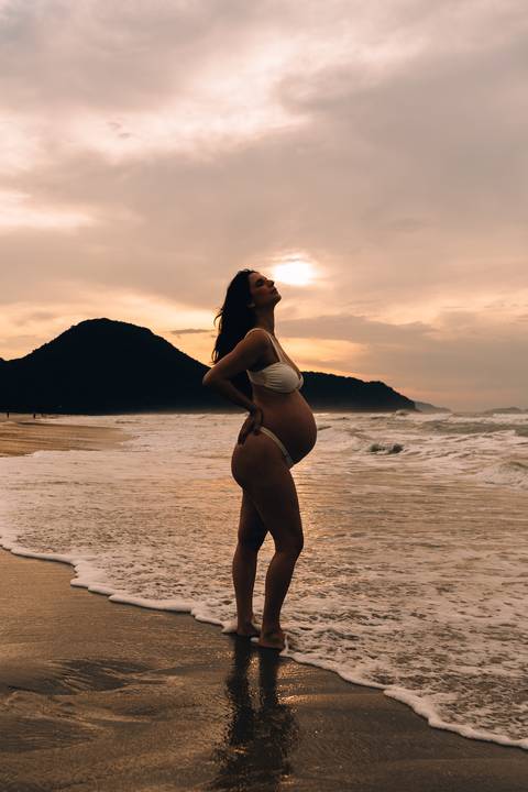 Ensaio gestante na praia em Ubatuba realizado ao pôr do sol.'