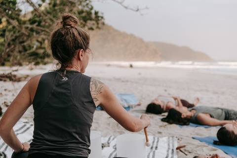 Grupo praticando Yoga ao ar livre durante retiro em Ubatuba'