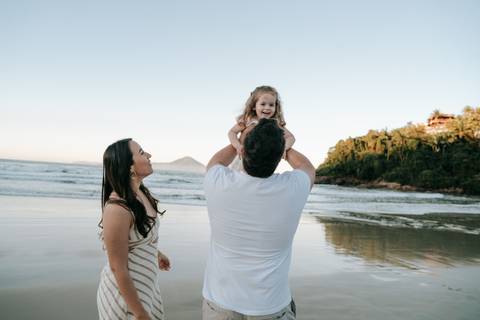 Pais brincando com os filhos durante ensaio família na praia em Ubatuba'
