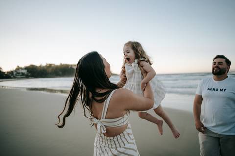 Pais brincando com os filhos durante ensaio família na praia em Ubatuba'