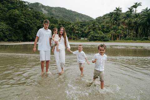 Criança correndo pela areia durante ensaio família em Ubatuba'