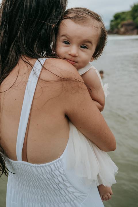 Mãe abraçando o filho durante ensaio fotográfico na praia de Ubatuba'