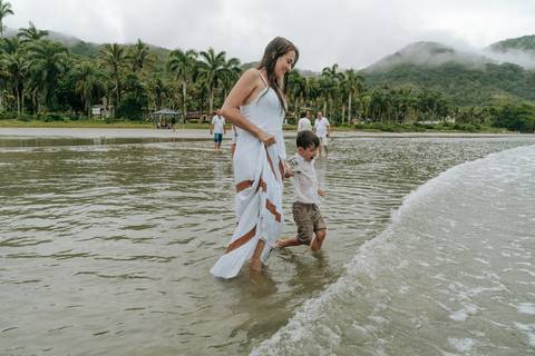 Mãe abraçando o filho durante ensaio fotográfico na praia de Ubatuba'