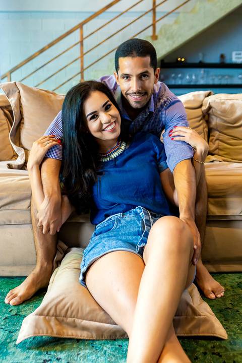 homem sentado no sofá e mulher no chão da sala do loft de macamirim'