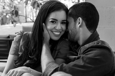 homem sentado e falando no ouvido de mulher no sofá da area externa do loft de macamirim'