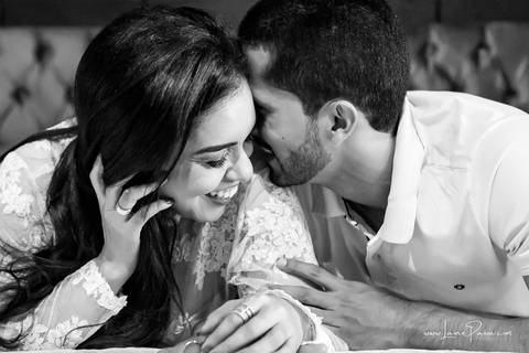 casal deitado na cama com homem falando alfo no ouvido da mulher que sorrir no quarto do loft de macamirim'