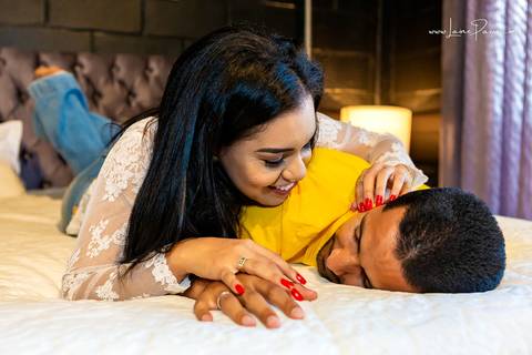 homem deitado na cama de costas e mulher por cima fazendo carinho e rindo na cama do quarto do loft de macamirim'