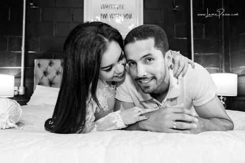 casal deitado na cama com homem dando carinho na mulher que sorrir no quarto do loft de macamirim'