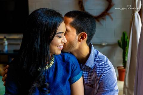 casal sentados em puff, homem falando no ouvido de mulher na sala do loft de macamirim'