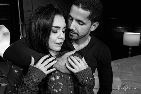 homem abraçando mulher por tras que esta de olhos fechado e segurando em seu braço no quarto do loft de macamirim'