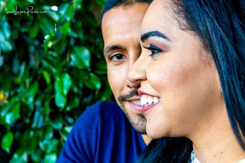 homem por trás de mulher olhando para frente e mulher com rosto de lado de olho fechado e sorrindo '