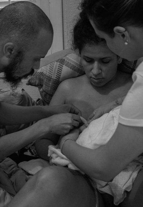 Ana com seu parceiro, em trabalho de parto humanizado em sua residência na zona sul da capital de são paulo. parto de cairo. Cairo nasce. cortando cordão umbilical do cairo.'
