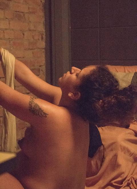 Ana com seu parceiro, em trabalho de parto humanizado em sua residência na zona sul da capital de são paulo. parto de cairo. Ana enquadrada, agachada em frente a sua janela.'