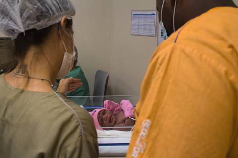 Francielle e seu parceiro no hospital são luiz do anália franco, na capital de são paulo. parto de yanna. médicas em parto humanizado cesariano. Yanna nascendo. doula e pai de Yanna olhando para ela no bercinho.'