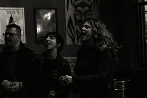 Banda ultra 77 no armazém 77 localizado na zona leste da capital de são paulo. galera cantando e pulando no show, público e clientes no bar.'