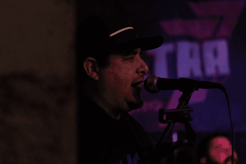 Banda ultra 77 no armazém 77 localizado na zona leste da capital de são paulo. markus enquadrado cantando no microfone, parede dividindo a cena.'