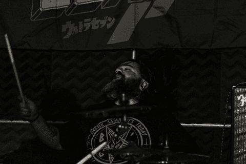 Banda ultra 77 no armazém 77 localizado na zona leste da capital de são paulo. leandro em movimento enquanto toca seu instrumento, a bateria. cabelo para trás.'