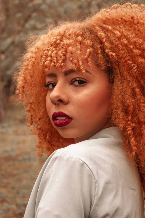 Amanda no parque do carmo, capital de são paulo, na época das cerejeiras. séria sensual, olhando diretamente para a câmera, lateral do corpo.'