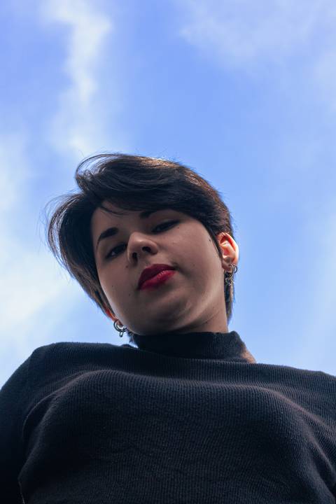 Bianca no quintal da sua casa na zona leste de são paulo. fundo de céu. olhando em direção a mim.'