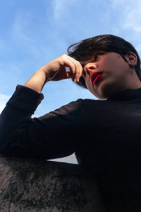 Bianca no quintal da sua casa na zona leste de são paulo. fundo de céu. olhando em direção ao horizonte.'