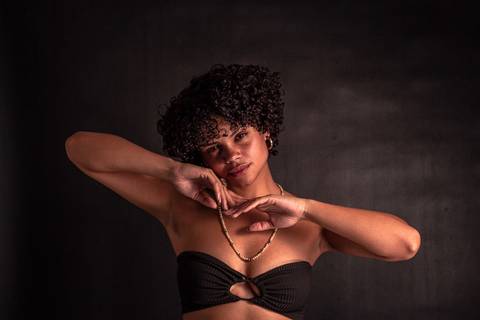 Cássia modelando em estúdio na zona norte da capital de são paulo. olhar sensual, mão próxima ao rosto, mais enquadrado. braços apoiam nas mãos, com os braços estendidos.'