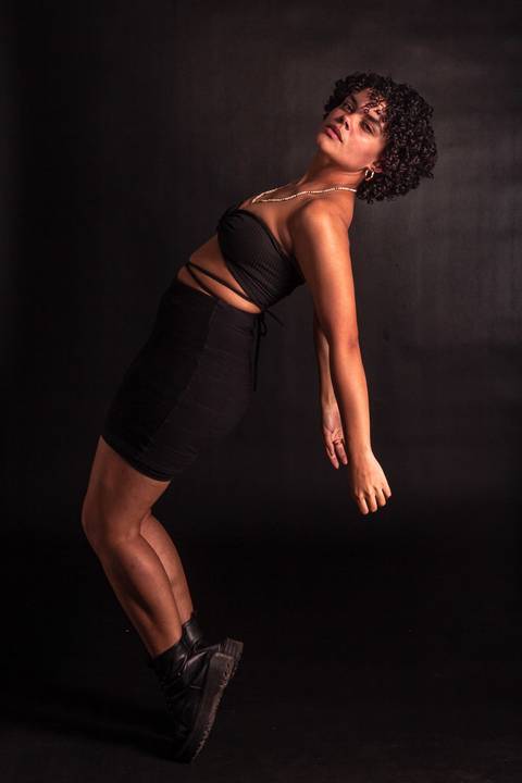 Cássia modelando em estúdio na zona norte da capital de são paulo. olhando diretamente para mim, corpo quase suspenso, movimento de dança.'