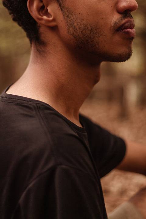 Isaque em meio as árvores, época de outono no parque do carmo, folhas ao seu redor, enquadramento mais fechado.'