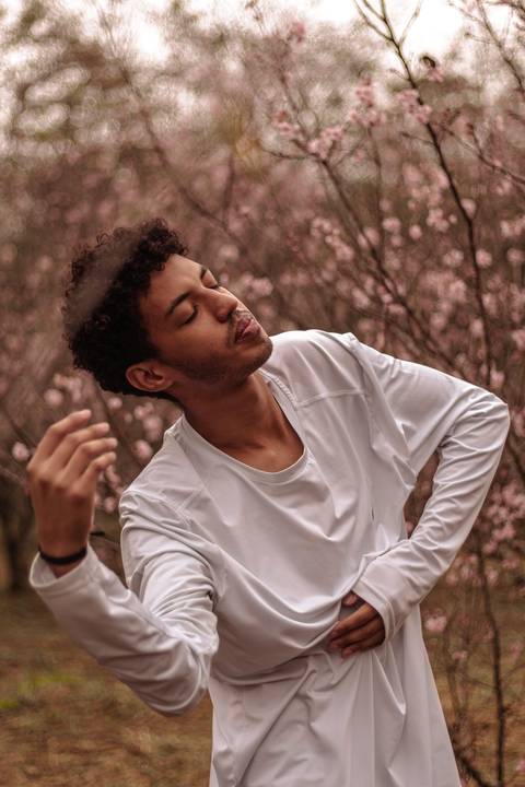 Isaque bailarino, sendo fotografado no parque do carmo na época das cerejeiras, enquanto faz coreografia.'