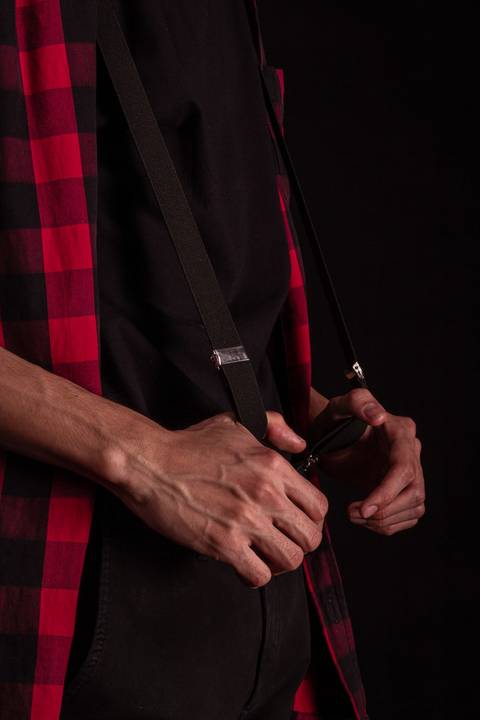 Jorge pegando em seu cinto, detalhe das mãos.'