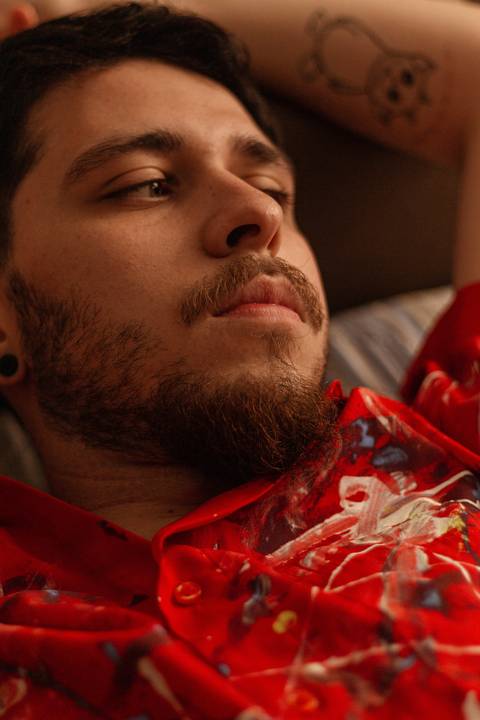 Matheus, deitado em seu sofá, olhando além do horizonte.'