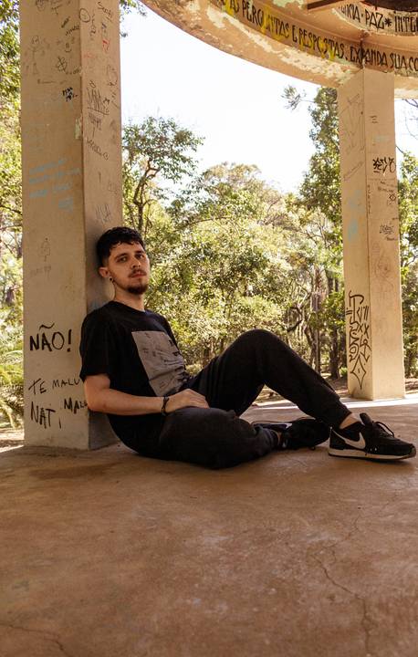 Matheus no parque do Ibirapuera, em são paulo capital, sentado debaixo de monumento.'