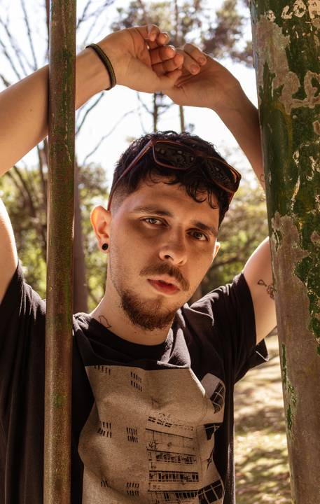 Matheus no parque do Ibirapuera, em são paulo capital, na lateral de monumento, enquadramento mais fechado no rosto.'
