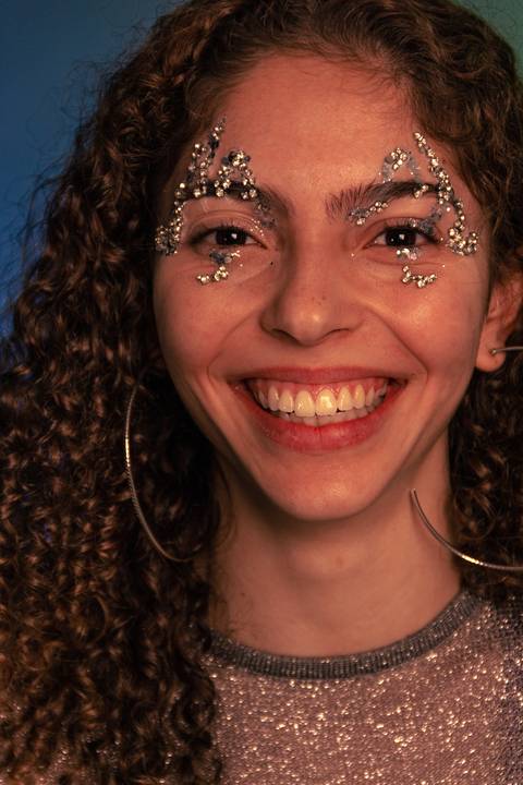 Geovanna sorrindo com o rosto focado e enquadrado total em tela.'