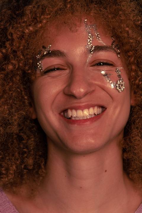 Lariane sorrindo solta com rosto enquadrado em foco.'