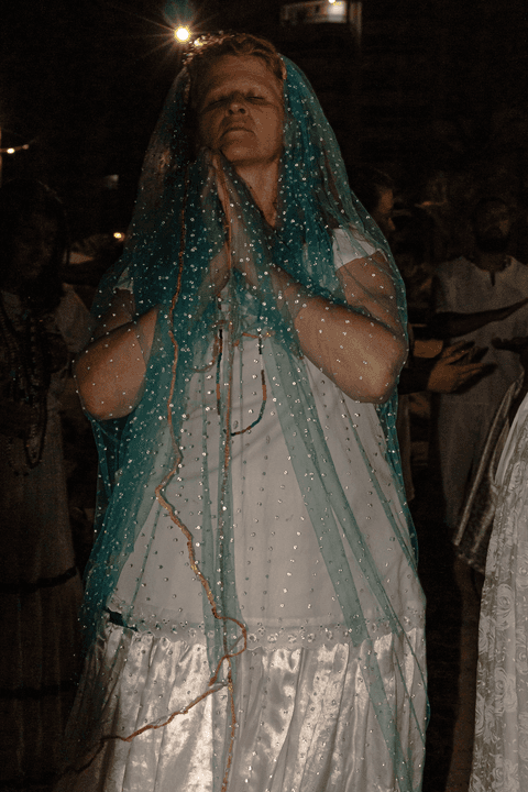 Entidade incorporada, envolta de um véu azul marinho.'