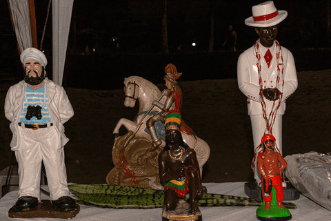Imagem de entidades da religião umbandista sobre a mesa, na praia grande.'