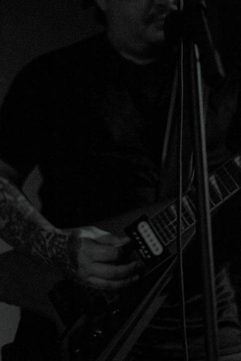 Show da ultra 77 no Armazém 77 Markus cantando e tocando baixo, foto em preto e branco'