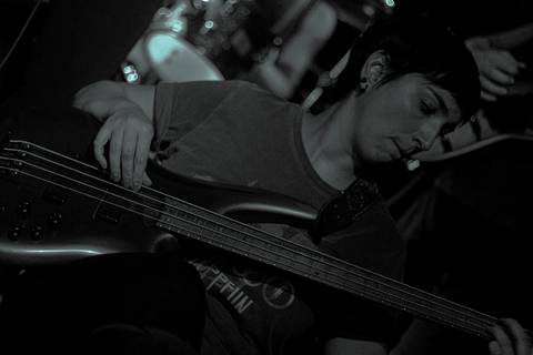 Show da ultra 77 no Armazém 77 lilian tocando seu baixo, focada e fazendo um som'