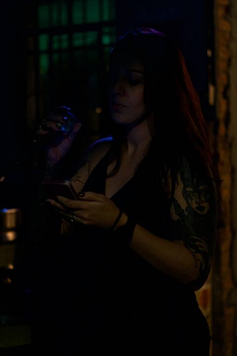 Show da ultra 77 no Armazém 77 ju cantando e olhando a letra no celular, foto em colorido'